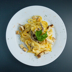 Overhead shot of creamy pasta dish with croutons and parsley on a white plate.