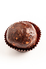 A tempting cocoa energy ball rests in a decorative paper cup, showcasing its dense texture