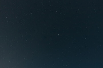 A calm, clear night sky filled with countless tiny stars, fading gently toward the horizon in a serene and peaceful celestial view.