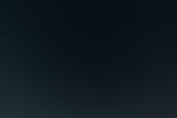 A calm, clear night sky filled with countless tiny stars, fading gently toward the horizon in a...