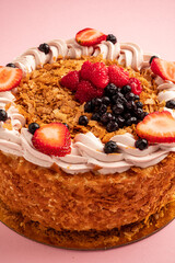 This beautiful cake features crispy layers, whipped cream, and an array of fresh berries on top