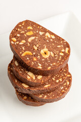 Sweet chocolate dessert with nuts served neatly on a simple white plate in a cozy kitchen