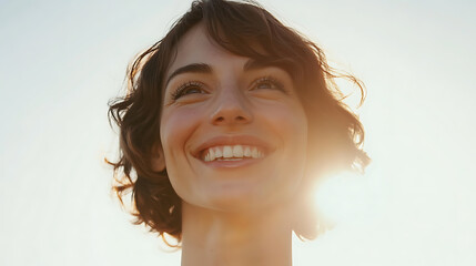 Radiant Woman: Capturing Joy & Optimism, bathed in warm light, her smile mirrors the sun's glow. A portrait of happiness and hope, against a bright sky.