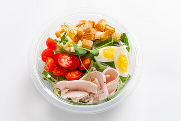 A colorful salad with cherry tomatoes, turkey, croutons, and soft-boiled eggs, great for lunch