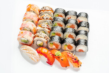 Vibrant assortment of sushi rolls and sashimi elegantly arranged on a white background