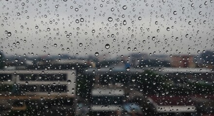 Raindrops on a glass surface overlooking a cityscape