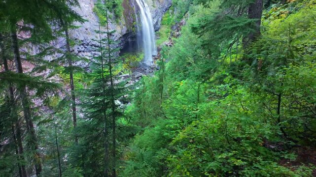 A scenic view of the beautiful Narada Falls cascading through a vibrant green forest at Mount Rainier National Park