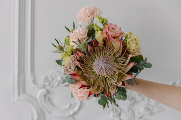 Close-up vertical shot of a diamond engagement ring in a delicate jewelry box next to a bridal...