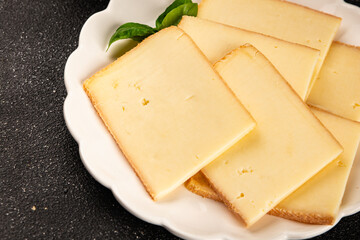 Raclette cheese portion slicing natural product tasty snack fresh delicious gourmet food background on the table rustic top view copy space