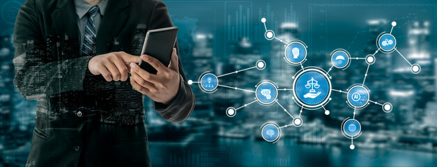 A businessman engages with a smartphone amidst a digital representation of justice scales and network connections, symbolizing modern legal technology and practices. Tessel