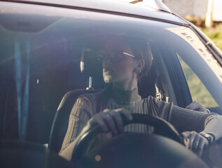 Woman driving car, looking nervously to the right, view through the windshield