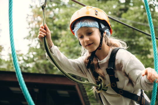 Child Navigating Adventure Park High Ropes Course - Powered by Adobe