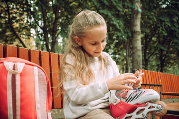 Child Putting on Roller Skates Outdoors