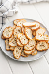 Crispy roasted bruschetta bread on plate on white table.