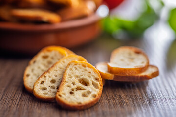 Crispy roasted bruschetta bread on wooden table.