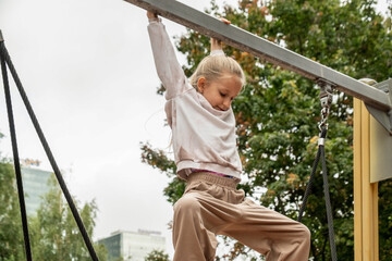 Child Playing Courageously on Playground Climbing Frame