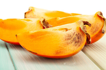 persimmon on wood background on white