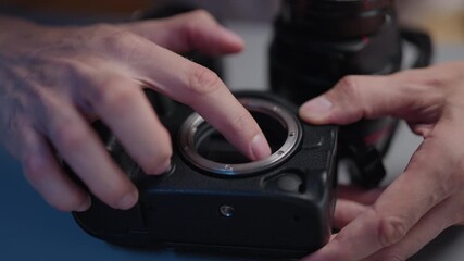 Close-up of photographer hands cleaning digital lens camera sensor, performing maintenance and service on professional dslr equipment, ensuring optimal image quality and preventing dust issues