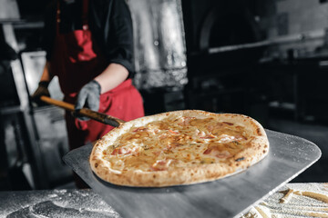Chef preparing fresh pizza in traditional pizzeria setting