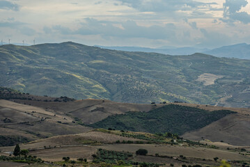 Mountainous central Sicilian landscape near Campofelice di Roccella, Italy, featuring rolling hills, distant Tyrrhenian Sea views, and the volcanic Islands on the horizon under