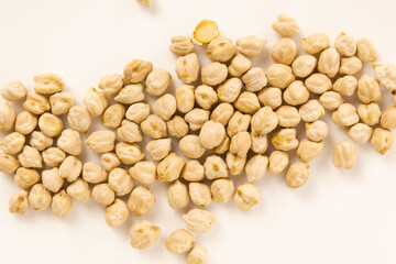Chickpeas arranged in a horizontal line over a white background