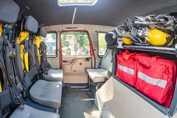 Fototapeta premium A well-lit, yellow and red emergency response vehicle interior with specialized seating, safety harnesses, and rescue equipment.