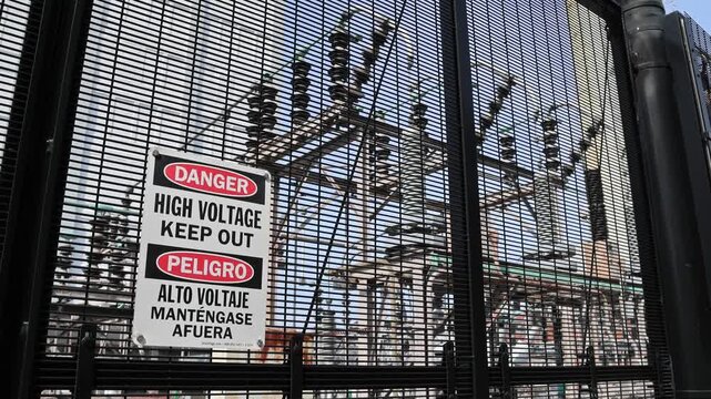 danger high voltage keep out sign in front of outdoor power plant in brooklyn new york (electricity generation transformer station electric current warning) fence alternating direct electrical grid