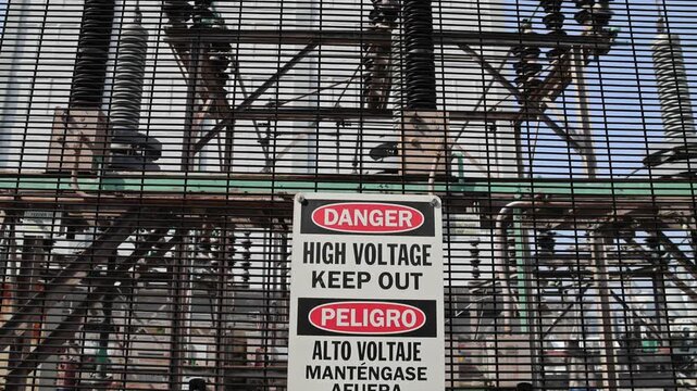 danger high voltage keep out sign in front of outdoor power plant in brooklyn new york (electricity generation transformer station electric current warning) fence alternating direct electrical grid