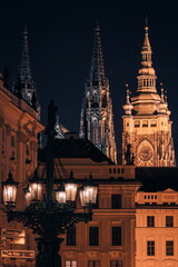 Obraz premium Night view of St. Vitus Cathedral and Prague Castle in Prague, Czech Republic, beautifully illuminated by golden lights against the dark night sky.