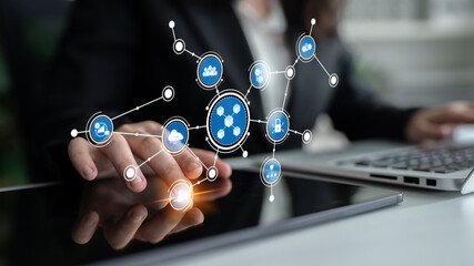 A business professional interacts with a digital tablet displaying network concepts and icons, symbolizing modern technology and communication in a dynamic office environment. Tessel