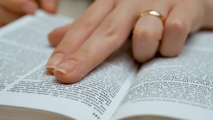 Fingers touch Holy Bible scripture and religion. Sacred book holds divine truth. Woman study Christian teachings. Verse carries deep meaning. Prayer reflection and spiritual understanding