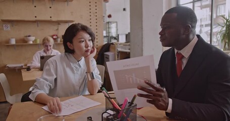 Multicultural business team discussing sales data in a modern office. They analyze charts and graphs to make informed decisions. Collaboration and diversity are key to their success. - Powered by Adobe