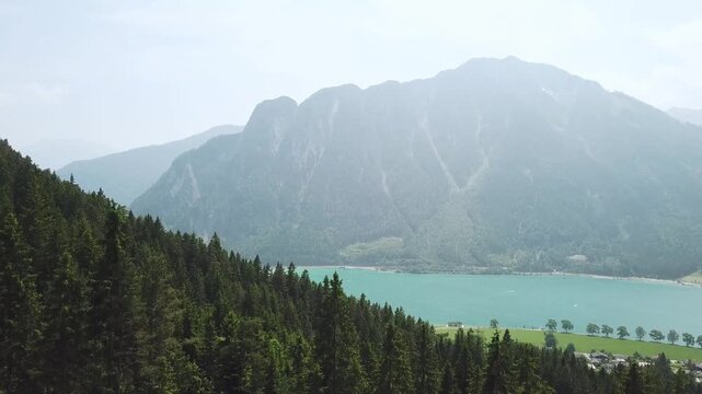 Stunning drone footage of Achensee lake in Tyrol, Austria. Clear turquoise water and majestic mountains create a breathtaking alpine view.
