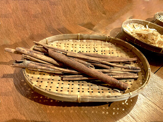 Cinnamon Sticks in Traditional Bamboo Basket on Wooden Table