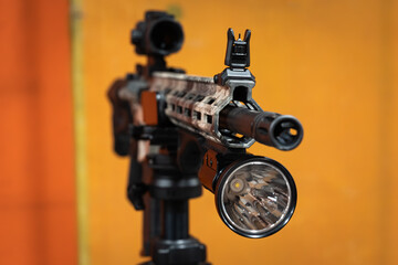 Close-up of a large, powerful tactical flashlight mounted on the rail of a modern custom rifle.