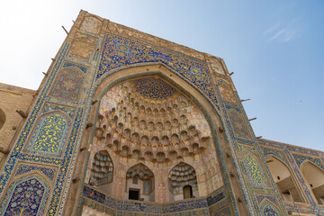 Obraz premium Abdulaziz Khan Madrasah, an ancient madrassah in Bukhara, Uzbekistan. It was built in 1652-1654. Mosaic Islamic text contains poems of ancient islamic poets