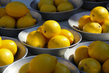 Close-up of still life with bowls of fresh lemons at a French street market.  