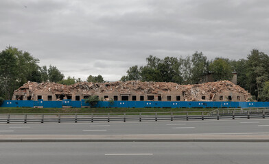 Demolished Soviet Five-Story Apartment Building with Rubble and Construction Fence