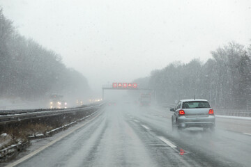highway with cars in winter with snow fall