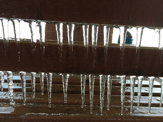 icicle in detail hanging on a board, background and symbol for winter