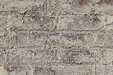 Fototapeta premium Old outdoor wall with chipped paint on the bricks.Wall repair and paint. Damaged outdoor wall and construction industry.