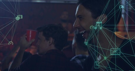 Laughing Black man raising red cup at dim bar counter, with teal network icons, copy space