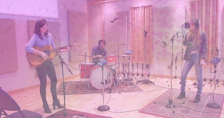 Performing music trio recording in sound studio, with acoustic guitar, drum kit and microphone