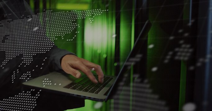 IT specialist typing on laptop keyboard in server room, with world map overlay and green-lit panels