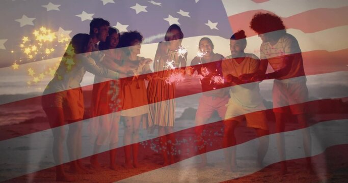 Holding sparklers, eight friends standing in loose circle on sandy beach at dusk, with flag overlay