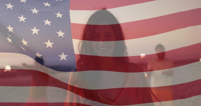 Smiling runner in red tank top jogging along sandy beach at sunset, with American flag overlay