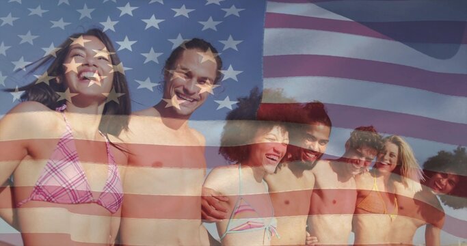 Smiling friends wearing bikini and swim trunks standing at beach edge, with American flag overlay - Powered by Adobe