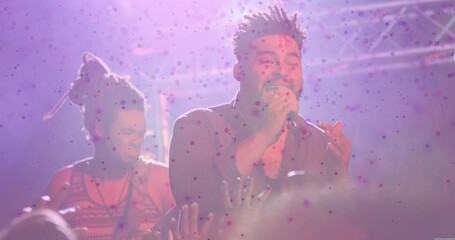 Singing African American singer holding microphone on concert stage, with electric guitar and haze