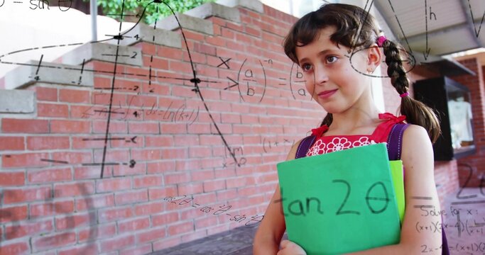 Standing student with purple backpack holding green notebook at school wall, with math, copy space
