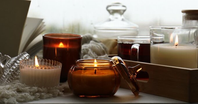 Burning candles and tea on table, closeup. Autumn atmosphere